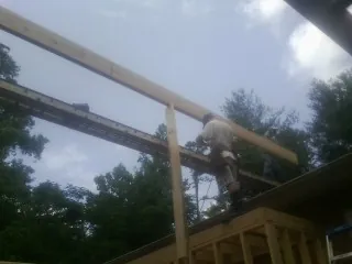 Carpenter setting a ridge beam over a new addition frame — Ice Dam Removal by Roofing Brothers in Shawano
