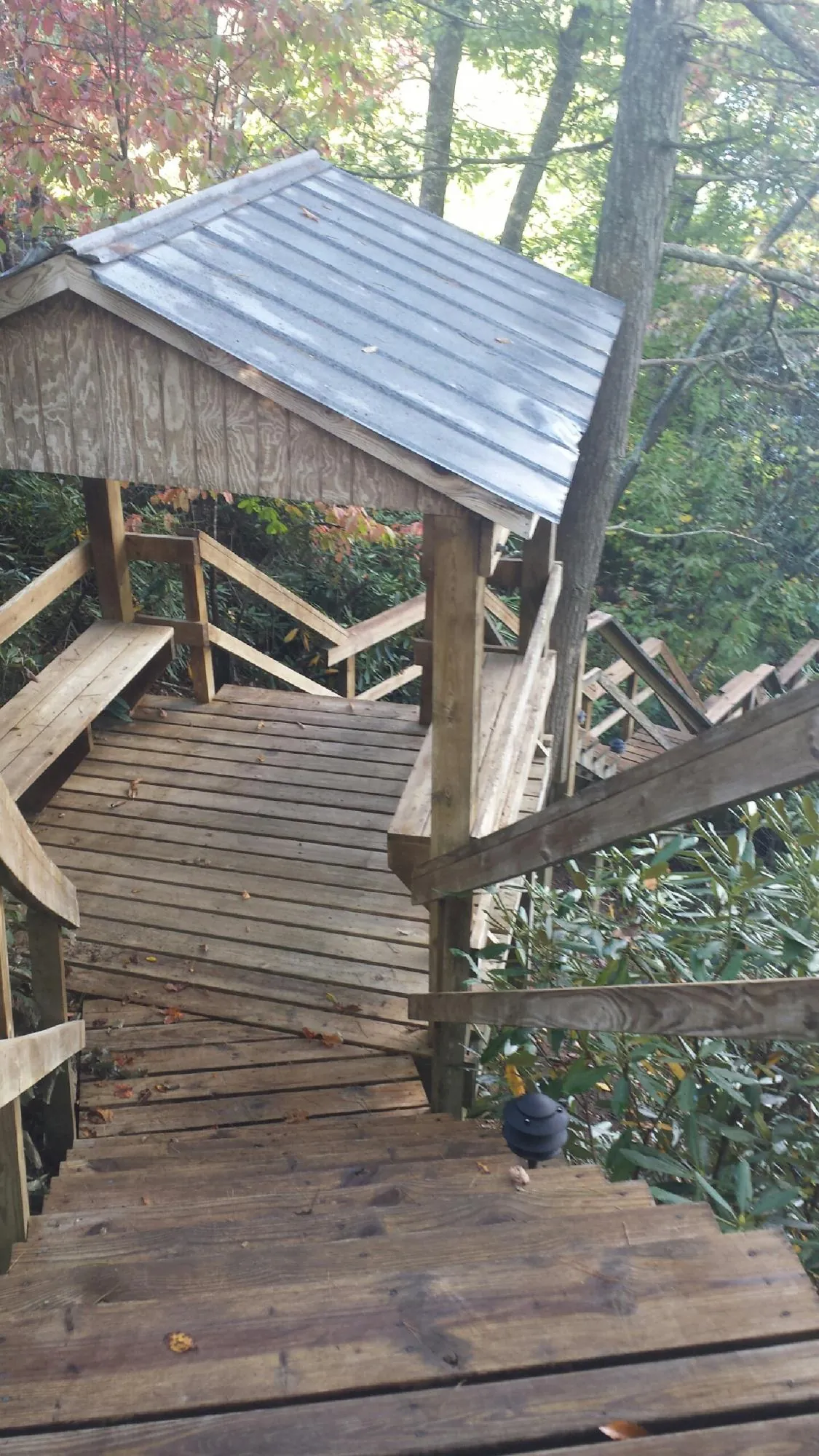 Metal roofed shelter over wooden steps on a wooded walkway — Skylight Repair & Installation work by our crew in Shawano